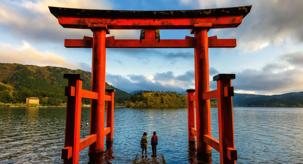 Casal nos portões torii vermelho de Hakone