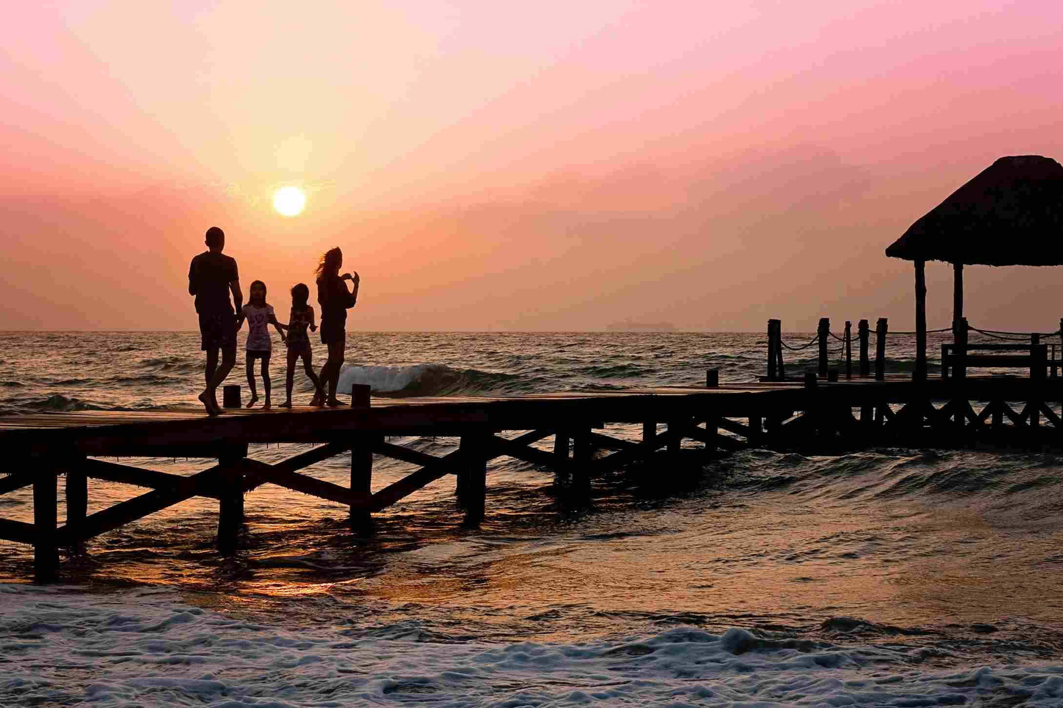 família em píer no por do sol